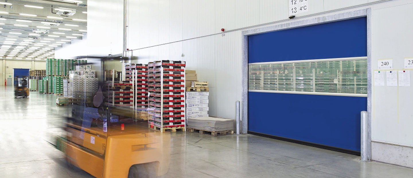 Blaues geschlossenes Schnelllauftor in einer Industriehalle.